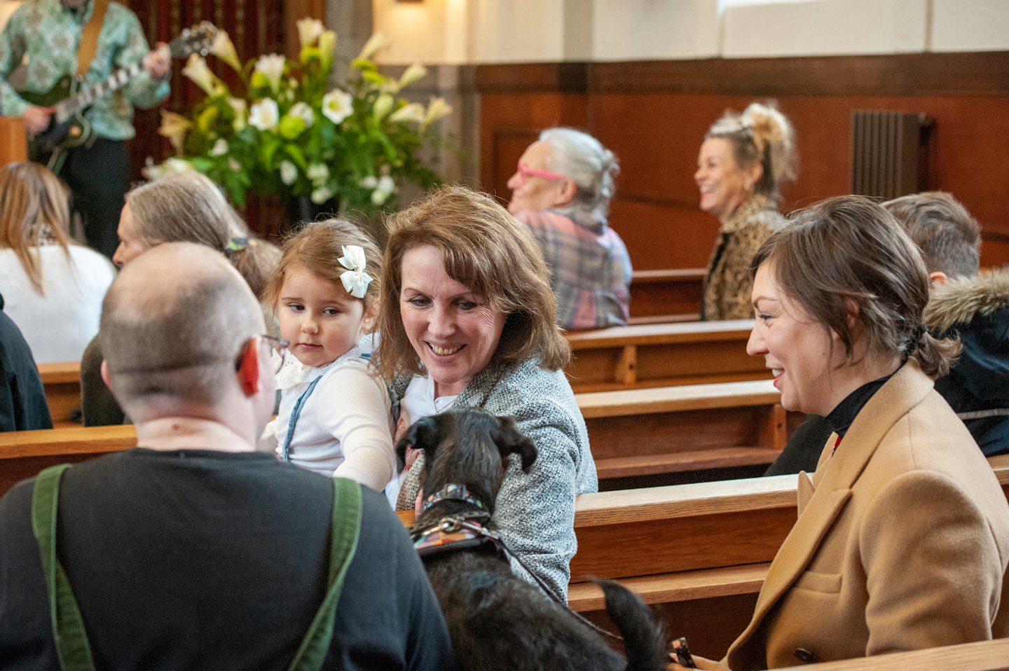 People in church pews smiling and listening.